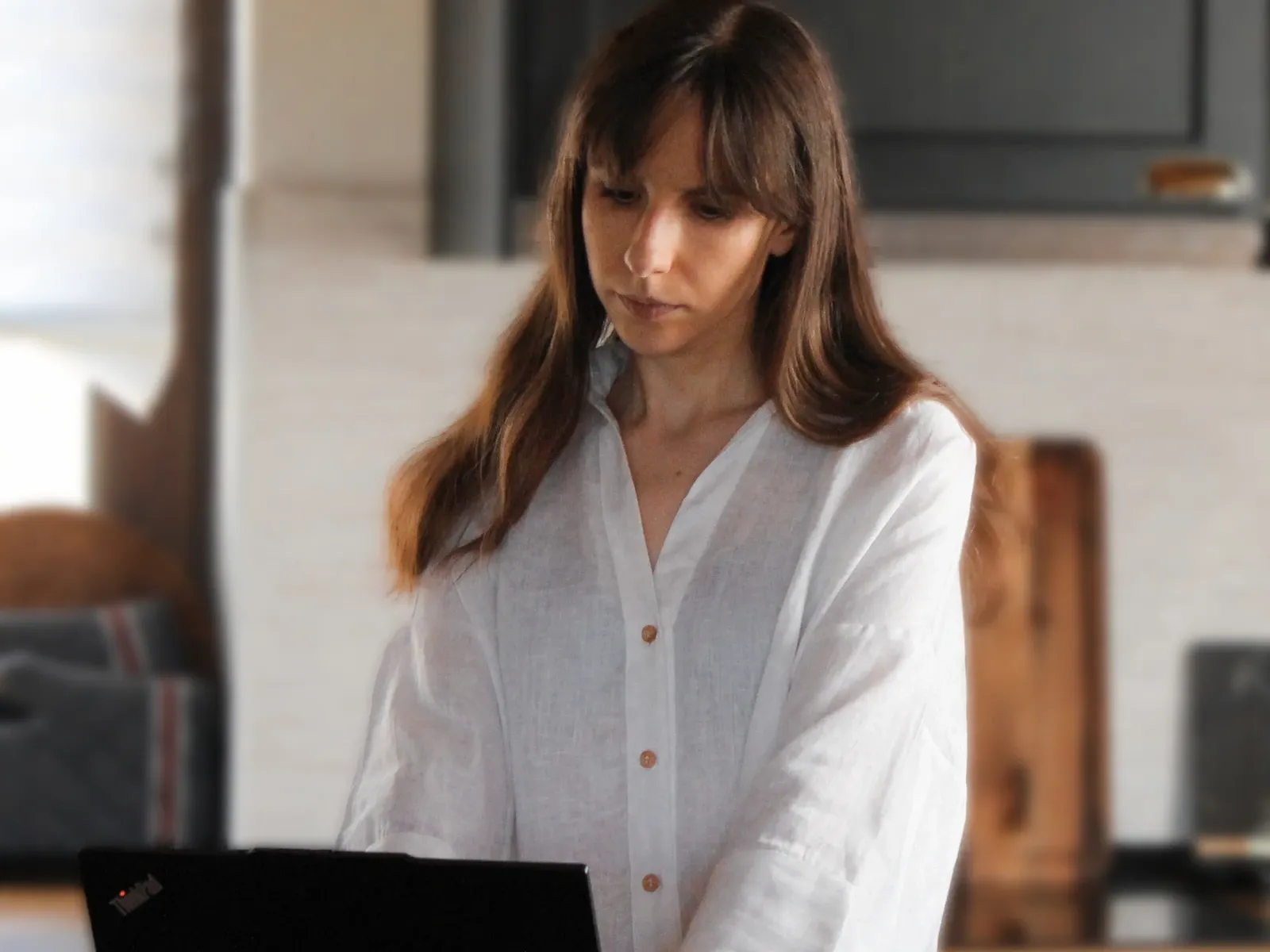 Jelena working on a laptop at her kitchen counter